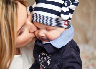 Kobieta całująca małe dziecko w policzek