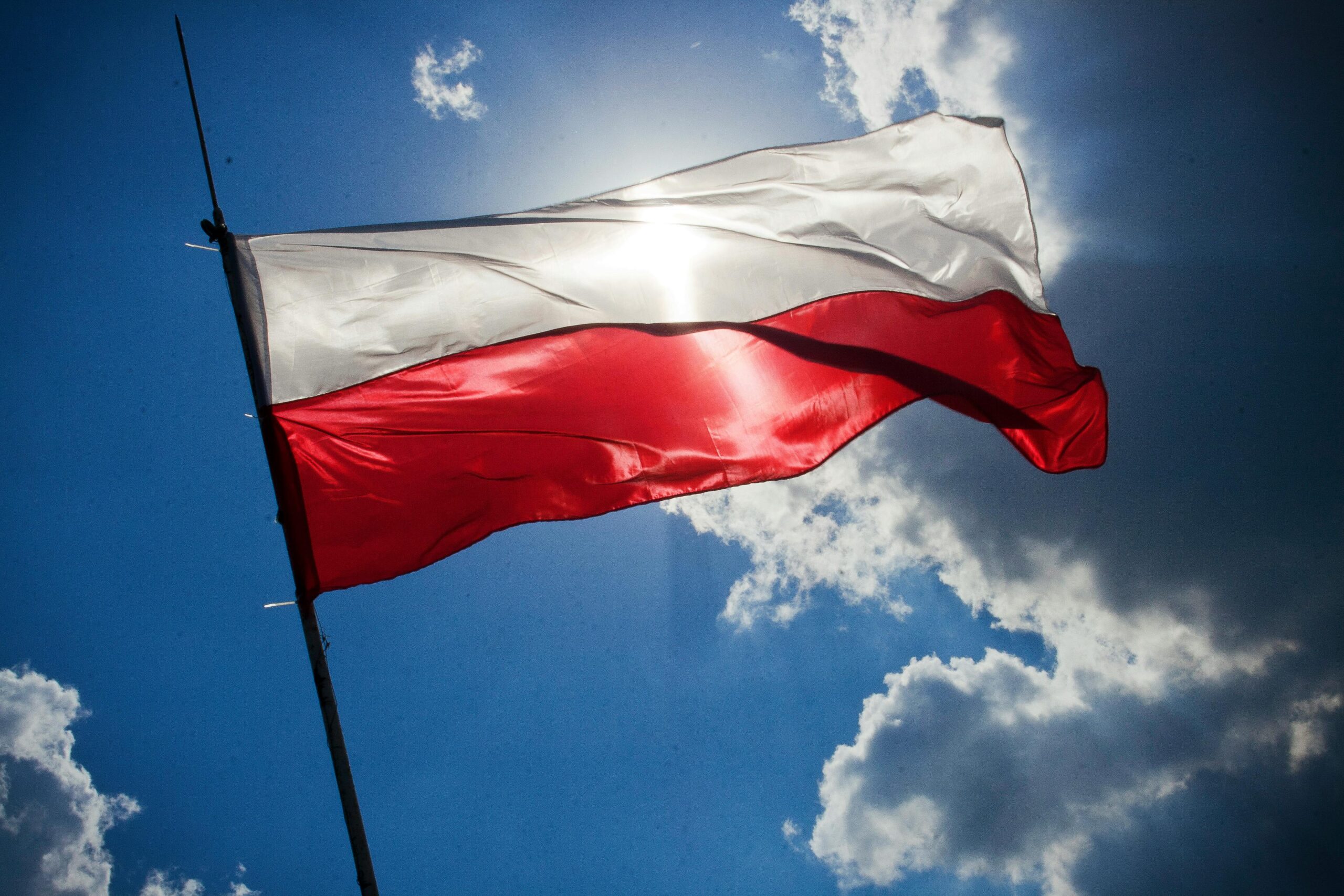 Flaga Polski powiewająca w promieniach słońca